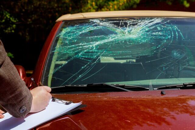 Insurance agent estimates the cost of damaged car after clash with a deer